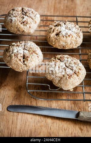 Freshly baked rye buns with muesli on cooling rack Stock Photo