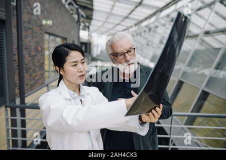 Female doctor discussing x-ray with senior patient Stock Photo