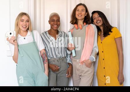 Portrait of four smiling women standing side by side Stock Photo