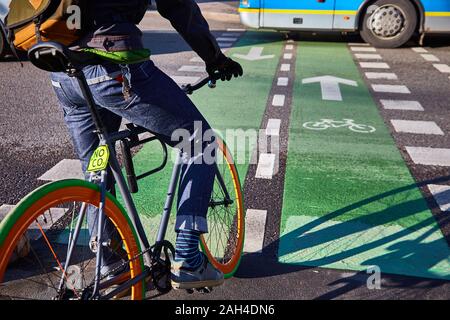 A cyclist in the city goes on a pedestrian crossing. Eco-friendly mode of transport. Bicycle with fixed speed