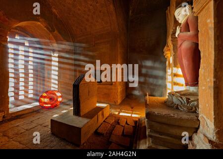 Ancient Buddhist temple with light rays through its window in Bagan, Myanmar Stock Photo