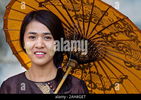 Local girl with thanaka on her face, in Mandalay, Myanmar. Thanaka is cosmetic paste made from ground bark Stock Photo