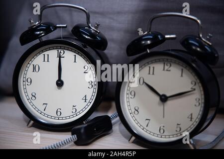 Retro clock on wooden texture front dark blue wall background. Vintage effect. Stock Photo