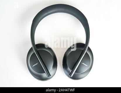 Montreal, Canada - December 23, 2019: Bose 700 Noise Cancelling headphones over a black background. Bose Corporation is a manufacturing company which Stock Photo