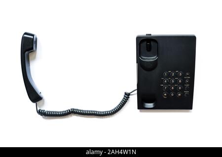 Simple modern push-button telephone of black color with a picked up handset isolated on a white background. Stock Photo