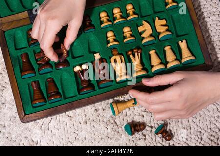 hands of woman putting the chess pieces in box Stock Photo