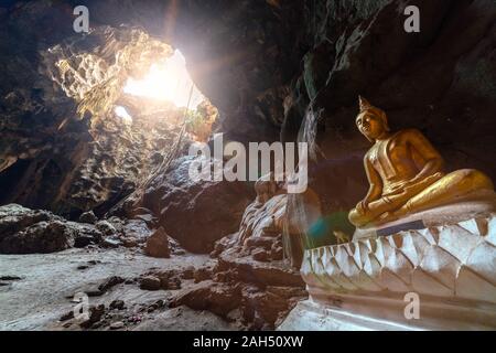 Buddha image with sun ray and lens flare in Khao Luang cave in Petchaburi, Thailand Stock Photo