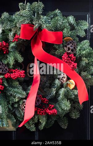 Christmas wreath on a black wooden house door. London, England Stock Photo
