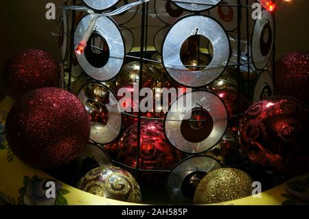 Red and gold Christmas bauble decorations at base of mini tree in the home Stock Photo