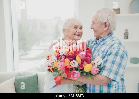 Portrait of her she his he two nice attractive cheerful cheery sweet, tender people granny receiving fresh floral tulips congratulations greetings spr Stock Photo
