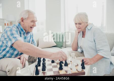 Profile side view portrait of her she his he two nice attractive bewildered concentrated focused people playing chess creating move, strategy win winn Stock Photo