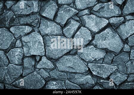 Gray stone wall background. Mosaic of bricks in retro style, modern. Dark rock texture, brick wall pattern. Grey grunge surface Stock Photo