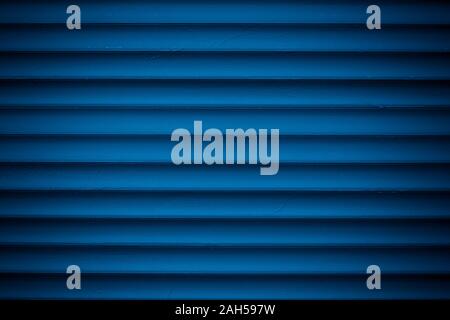 Dark blue metallic striped surface. Metal wall siding. Striated fence with shine. Convex wall texture. Ribbed surface of metal jalousie, door. Abstrac Stock Photo