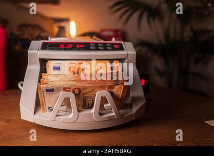 Counting 50 Euro bills in a machine Stock Photo