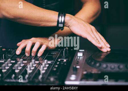 DJ controls a remote at a club party Stock Photo