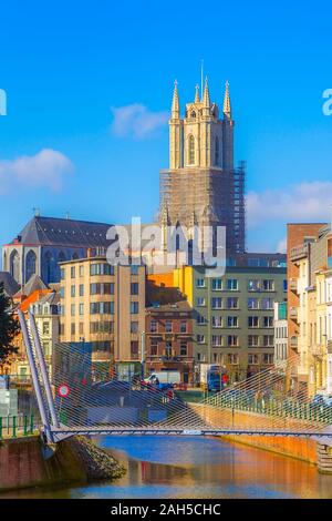 Ghent, Belgium - April 12, 2016: Street view, canal and tower of St Bavo's Cathedral in popular touristic destination Gent Stock Photo