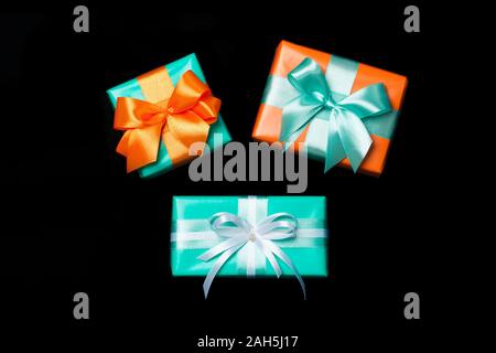 Stack of attractive gifts isolated on the black background. Present for St. Valentine's day, weddings, engagements, Mother's Day, birthday, New Year, Christmas, holidays. Flat lay Stock Photo