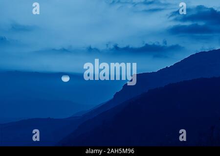 Toned image with trend color of 2020 year Classic blue. Scenic view of amazing pink-yellow sunset in Sicilian mountains with beautiful cloudscape Stock Photo