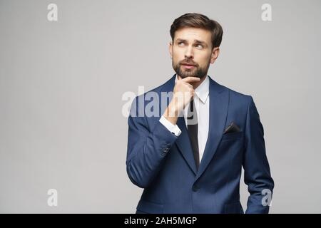 Studuo shot of thinking businessman wearing suit Stock Photo