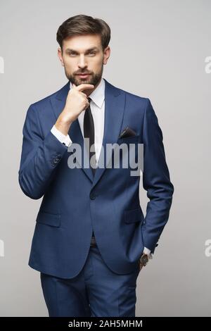 Studuo shot of thinking businessman wearing suit Stock Photo