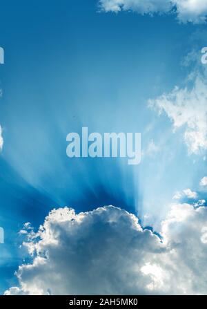 Sun rays bursting through clouds in a blue sky. Stock Photo