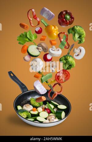 grilled fresh vegetables flying isolated on orange background Stock Photo