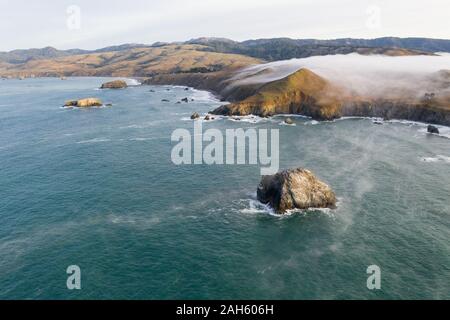 The Pacific Ocean washes against the scenic coastline of northern California in Sonoma. This region is often covered by a thick marine layer of mist. Stock Photo