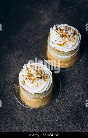 Cakes with white cream and on a black background. Baking and sweets. Stock Photo