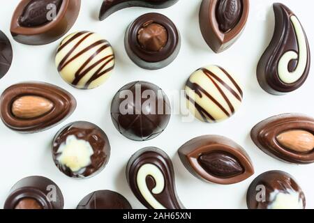 Background of different chocolates on a white background. Flat lay Stock Photo