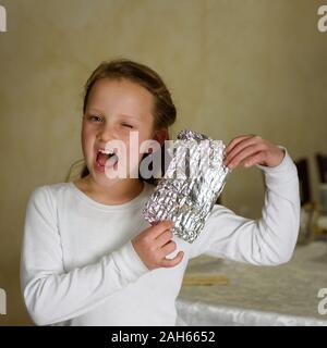 Girl Found it. Afikoman is a half piece of matzo which is broken of the Passover Seder. In many families the father takes the afikoman and hides it.The child that finds the afikoman receives gift. Stock Photo