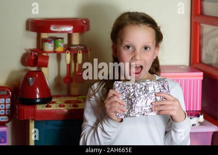 Girl Found it Afikoman is a half-piece of matzah which is broken of the Passover Seder.In many families the father takes the afikoman and hides it.The child that finds the afikoman receives gift. Stock Photo