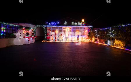 Poole, UK. 25th December 2019: Residential houses in Poole are lit up for Christmas on Runton Road. Home owners invite onlookers with optional charity donations. Credit: Thomas Faull/Alamy Live News Stock Photo