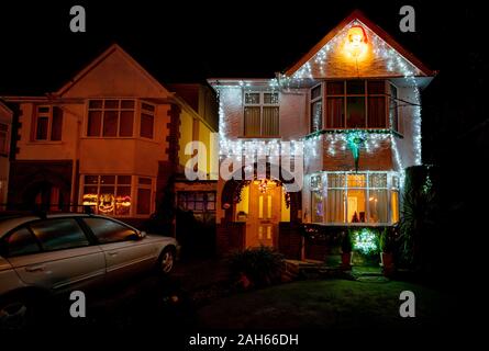 Poole, UK. 25th December 2019: Residential houses in Poole are lit up for Christmas on Runton Road. Home owners invite onlookers with optional charity donations. Credit: Thomas Faull/Alamy Live News Stock Photo