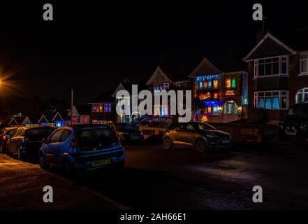 Poole, UK. 25th December 2019: Residential houses in Poole are lit up for Christmas on Runton Road. Home owners invite onlookers with optional charity donations. Credit: Thomas Faull/Alamy Live News Stock Photo