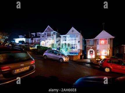 Poole, UK. 25th December 2019: Residential houses in Poole are lit up for Christmas on Runton Road. Home owners invite onlookers with optional charity donations. Credit: Thomas Faull/Alamy Live News Stock Photo