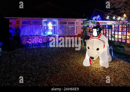 Poole, UK. 25th December 2019: Residential houses in Poole are lit up for Christmas on Runton Road. Home owners invite onlookers with optional charity donations. Credit: Thomas Faull/Alamy Live News Stock Photo