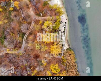 Drone picture of derelict abandoned concrete barge on river bank in fall Decaying alongside a river. Stock Photo