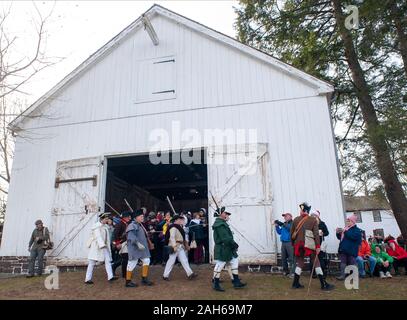 Washington Crossing, Pennsylvania, USA. 25th Dec, 2019. Soldiers march past a barn as they ready to go to their boats during the official Christmas Day Crossing of the Delaware reenactment by George Washington and his troops  Wednesday, December 25, 2019 at Washington Crossing State Park in Washington Crossing, Pennsylvania. (WILLIAM THOMAS CAIN / PHOTOJOURNALIST) Credit: William Thomas Cain/Alamy Live News Stock Photo
