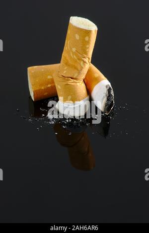 Crushed cigarette butts isolated on black background Stock Photo