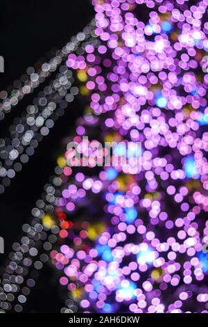 Defocused christmas tree bokeh lights of phantom blue violet color blur background. Stock Photo