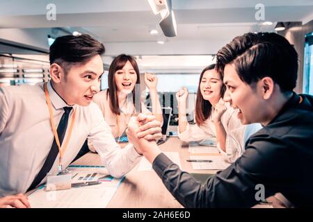 Businessman Competing In Arm Wrestling  at office Stock Photo