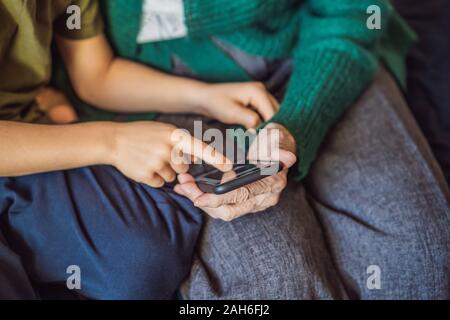 Grandmother and grandson are looking at a smartphone Stock Photo