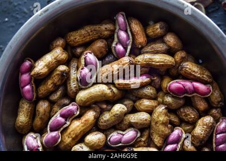 Top shot of boiled peanuts or groundnuts, macro shot of peanuts, some shelled with pink groundnuts visible Stock Photo