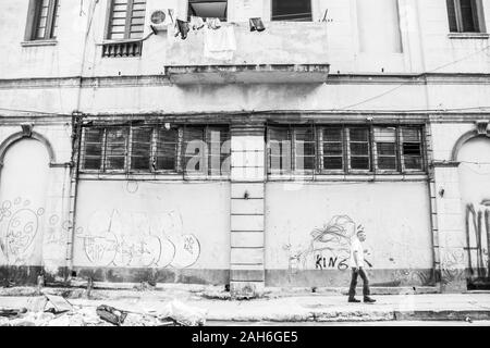 People of Havana Series - A lone, Cuban man, walking down the sidewalk in front of a building. Stock Photo