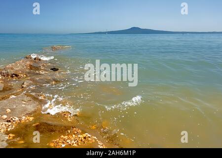 Rangitoto Island, a dormant volcano and wildlife sanctuary, viewed from St Heliers Beach, Auckland, New Zealand Stock Photo