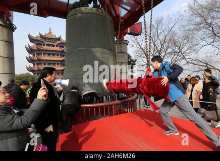 (191226) -- BEIJING, Dec. 26, 2019 (Xinhua) -- A visitor strikes the big bell at the Huanghelou Park in Wuhan, central China's Hubei Province, Feb. 5, 2019. Urban parks in China offer easy place for people to relax and unwind. Furthermore, China's urban parks feature more less-impact exercise equipment and ways to have fun for young and old. With the breeze blowing and boats floating in the parks, people enjoyed dancing, singing and folklore performance from 1950s to 1990s. Nowadays, people have more choices of activities in the parks, like the fashion show by the elderly locals and the l Stock Photo