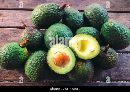 Whole and sliced avocado on wood Stock Photo