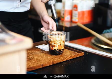 a cup of brown sugar flavored tapioca pearl bubble milk tea in night market of Taiwan background, Stock Photo
