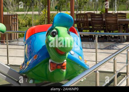 Children's amusement park with swings and green turtle Stock Photo