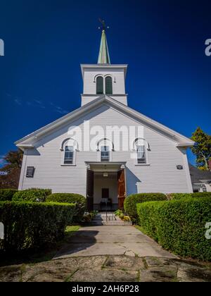 Symmetrical shot of a protestant wooden church in New England under a spotless blue sky